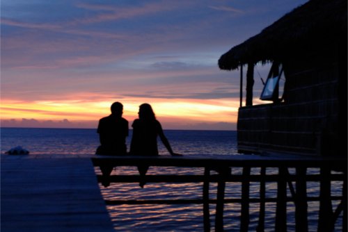 couple sitting under sunset